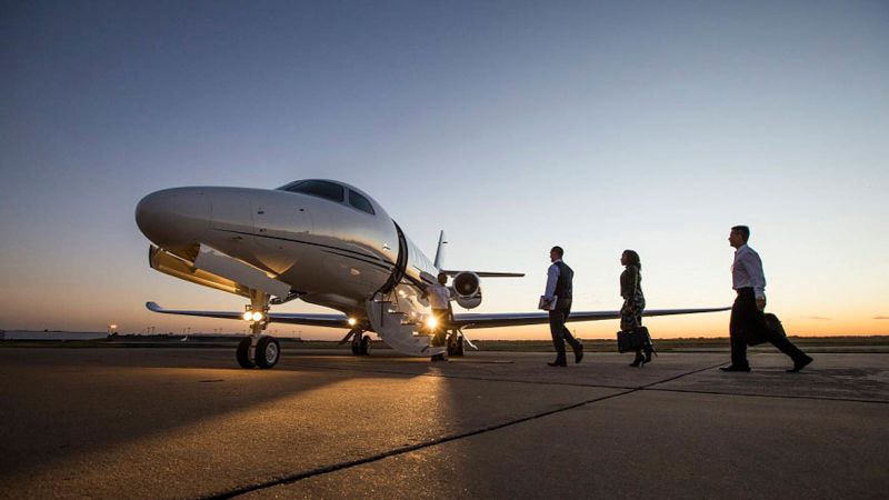 Passengers boarding a business jet at dusk